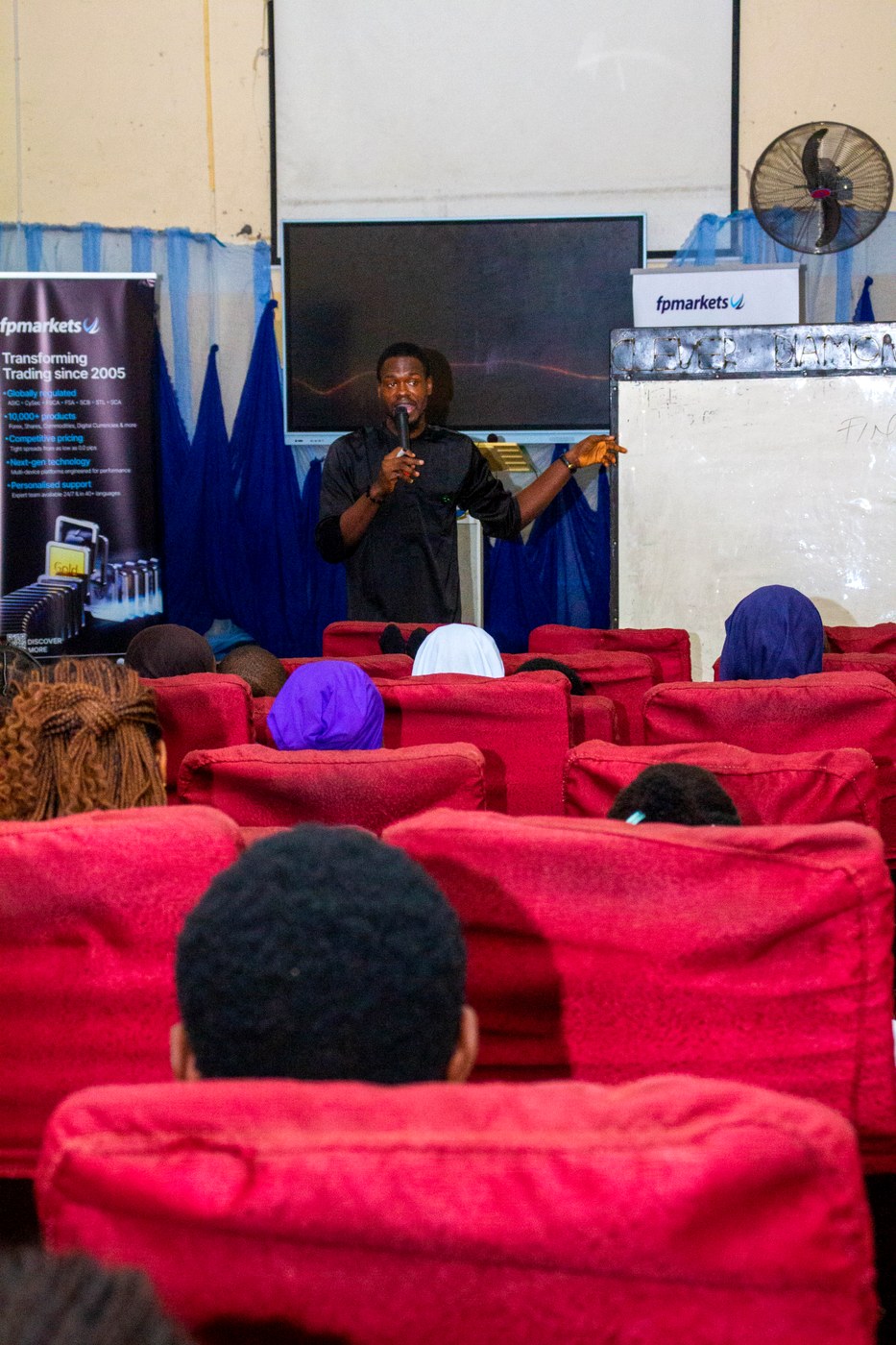 Joshua C. Okereke speaking to an audience at a financial literacy event